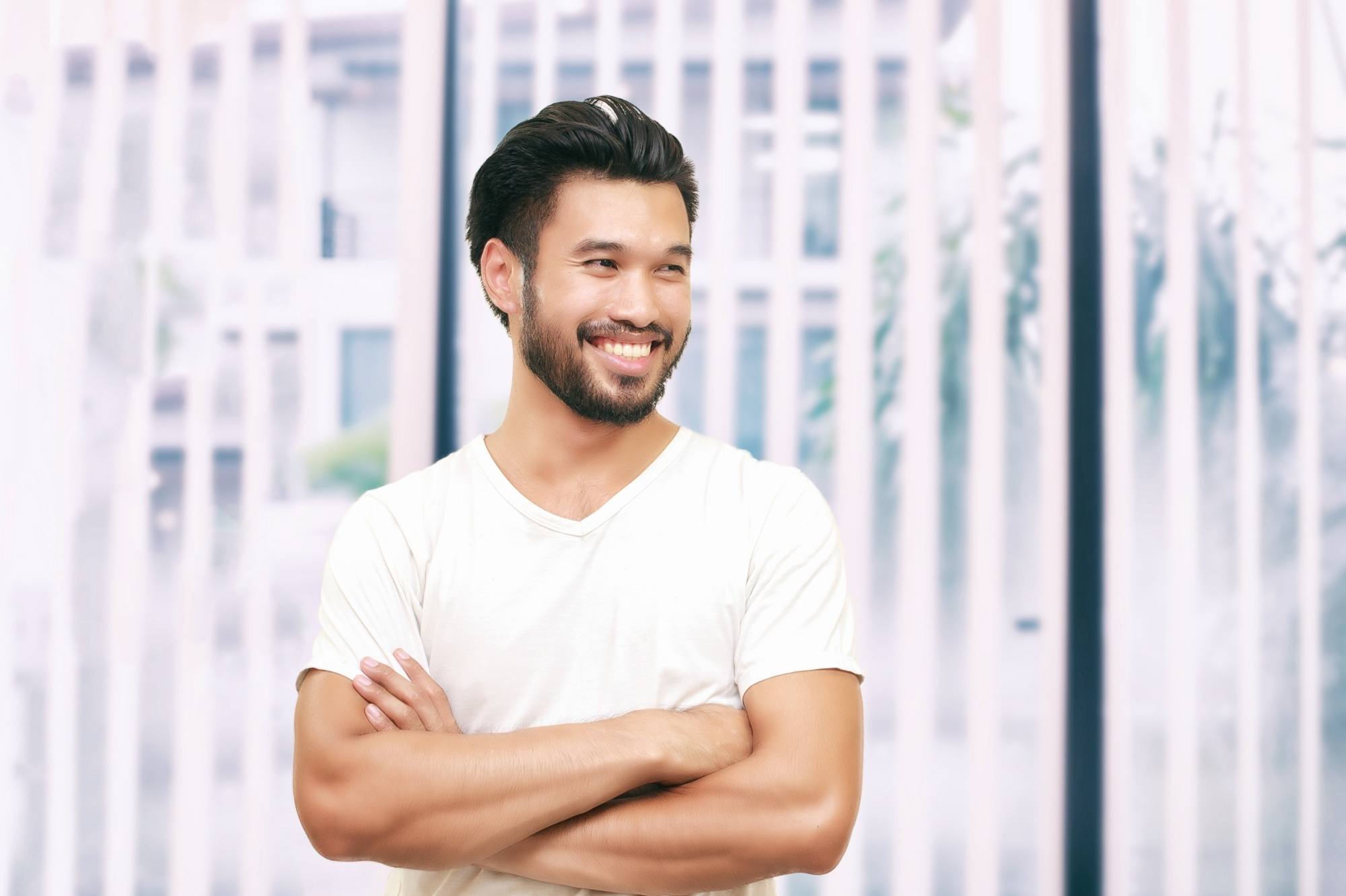 Asian man with a beard smiling and wearing a white shirt