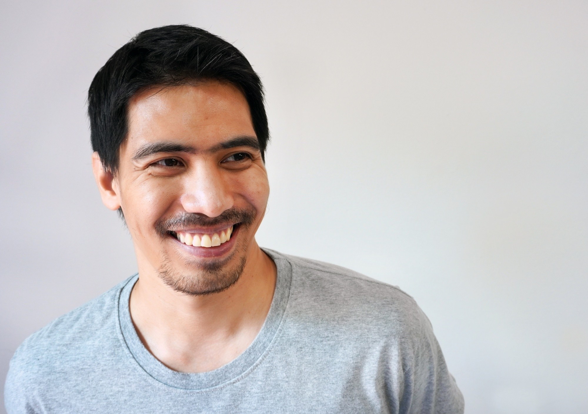 Asian man with a mustache smiling