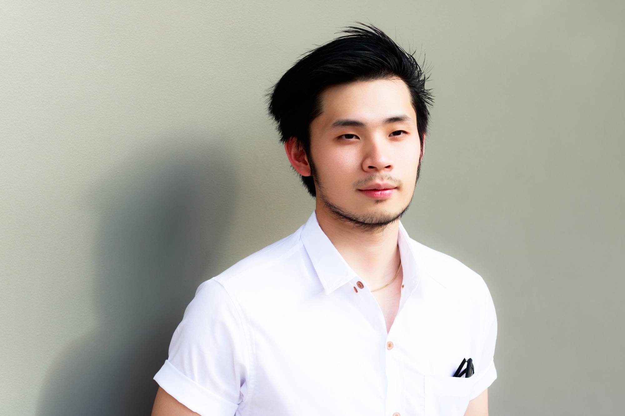 Asian man with a chin strap beard wearing a white shirt