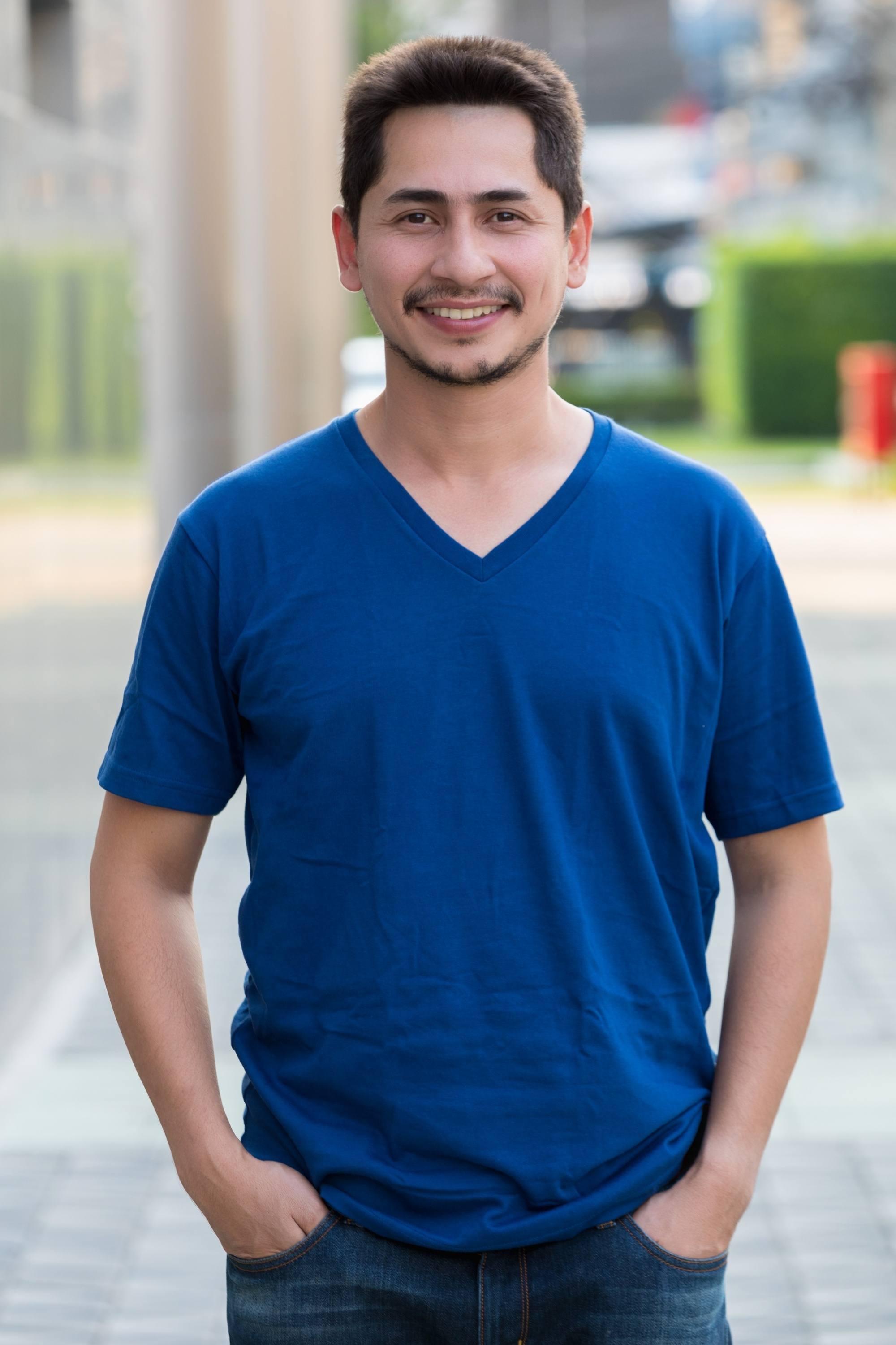 Asian man smiling and wearing a blue shirt