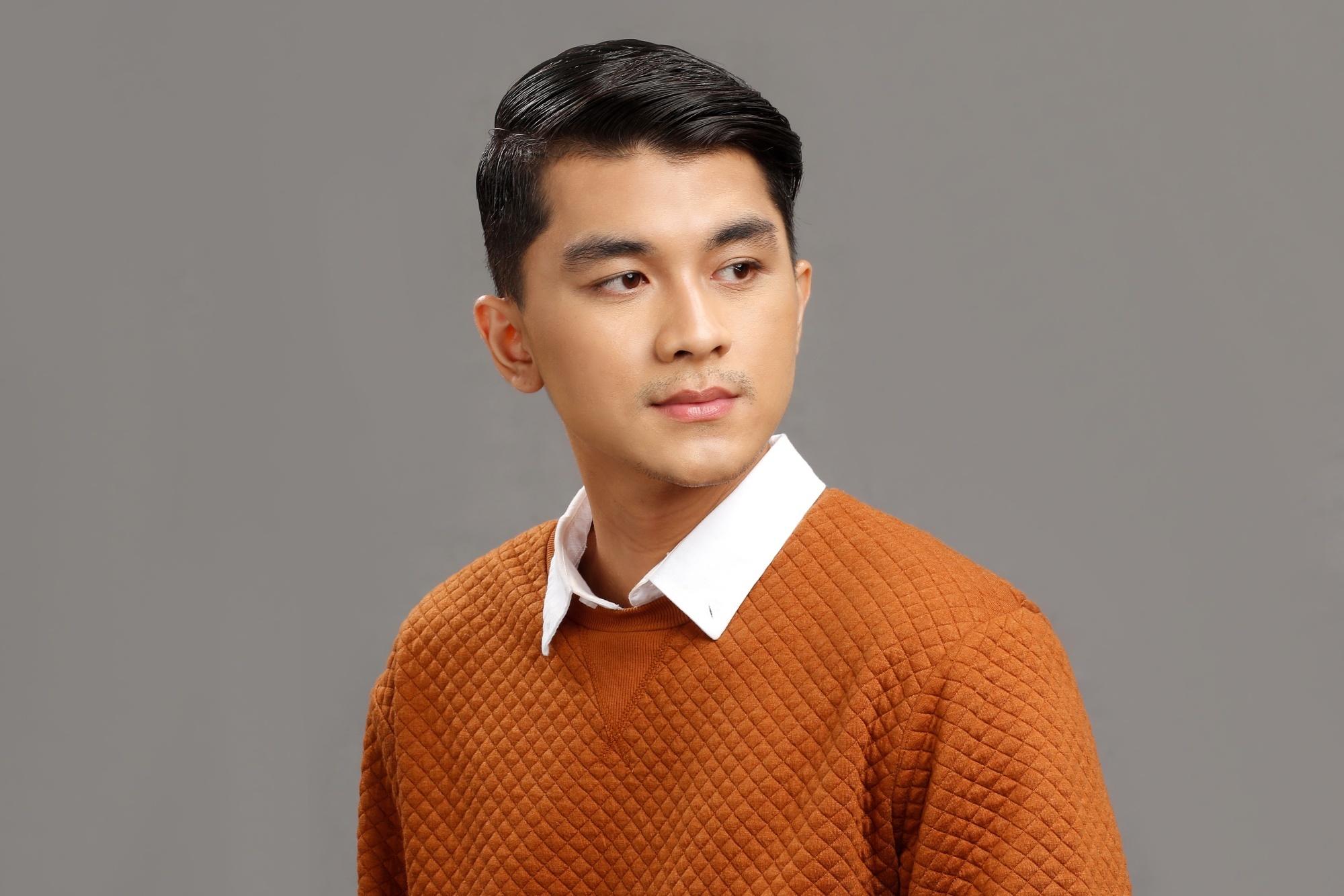 Asian man with a short haircut wearing a rust-colored shirt
