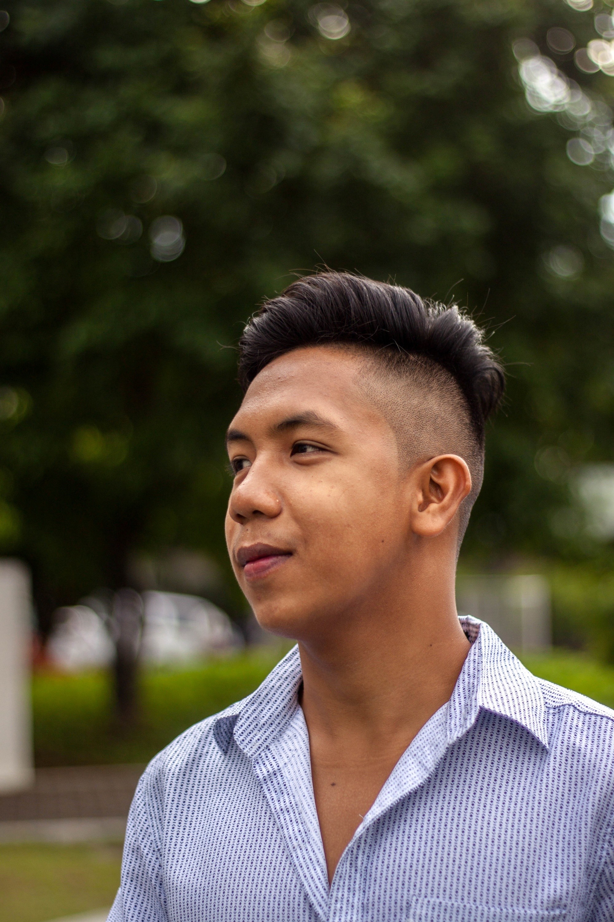 Filipino man with an undercut haircut wearing a light xanh rớt polo