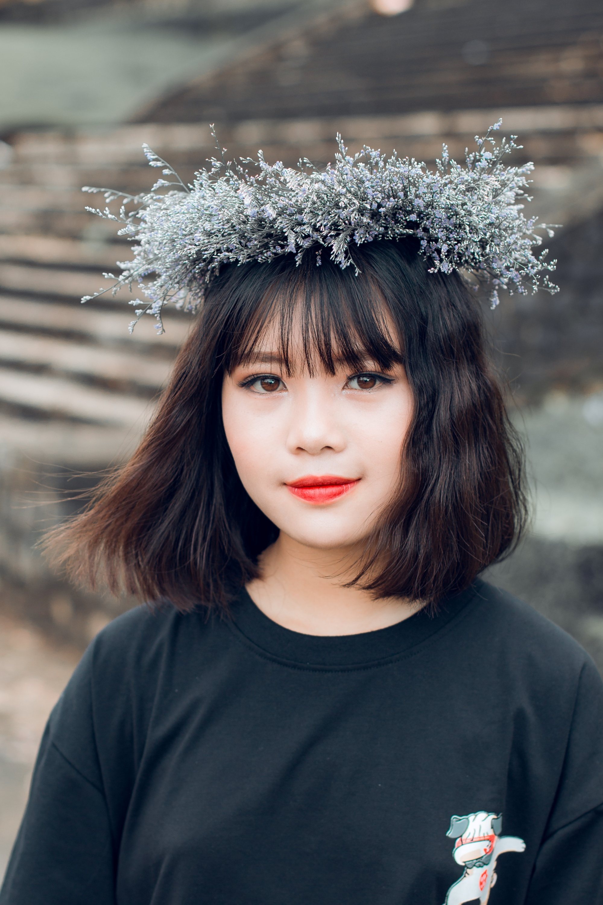 Asian woman with short wavy hair and bangs wearing a flower crown