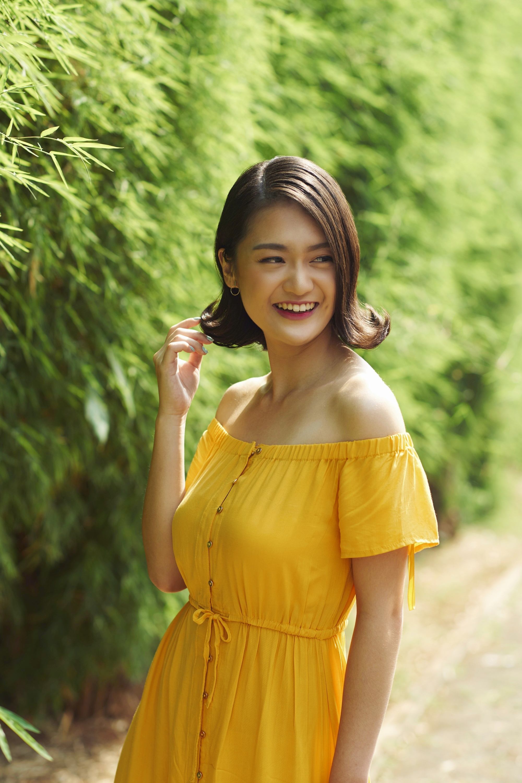 Asian woman with a flipped-out short hair for round face wearing a yellow dress