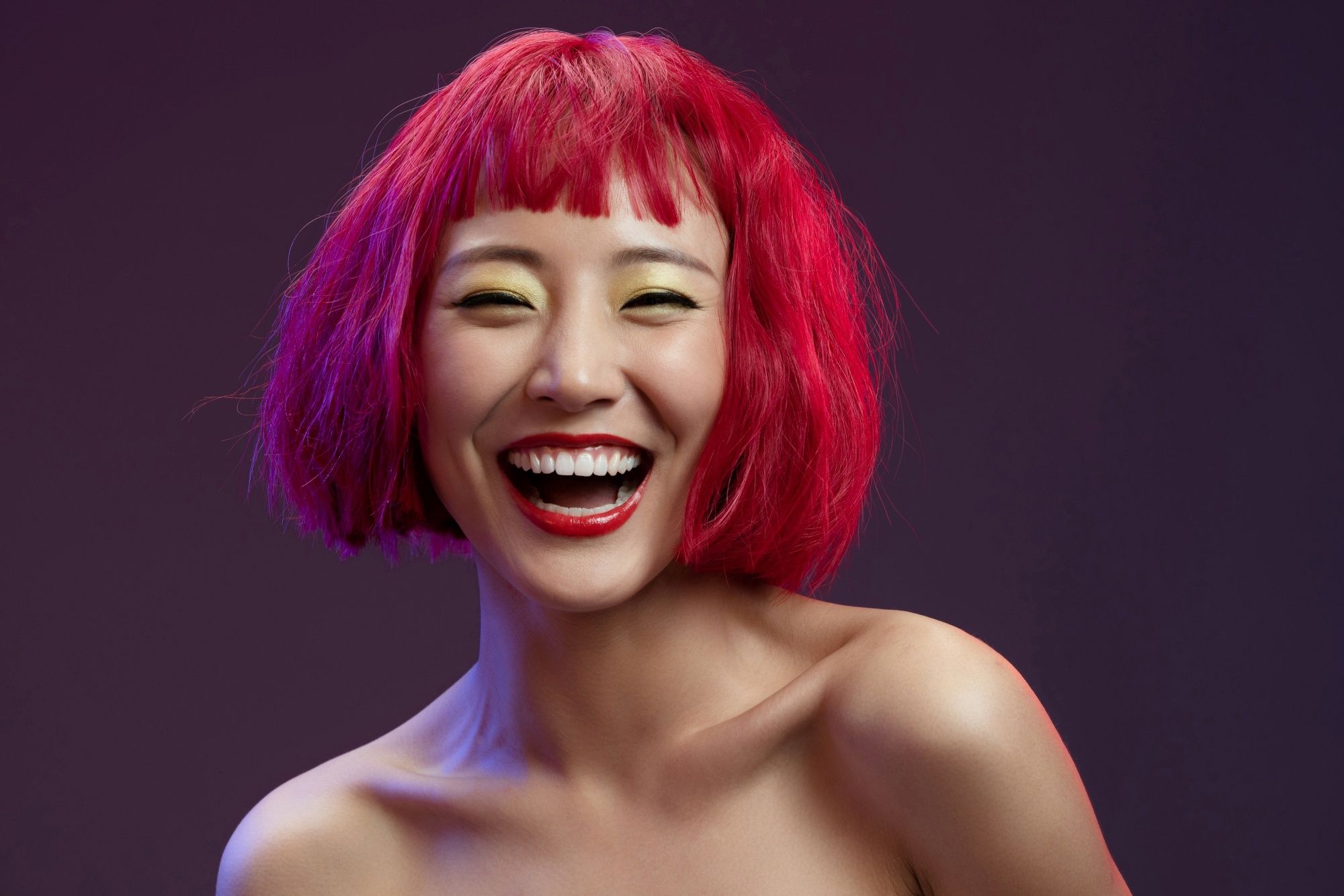 Woman with short red hair and bangs smiling