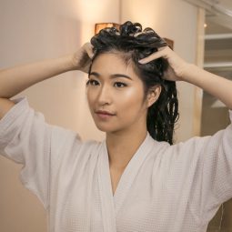 Asian woman applying dandruff treatment shampoo on her scalp