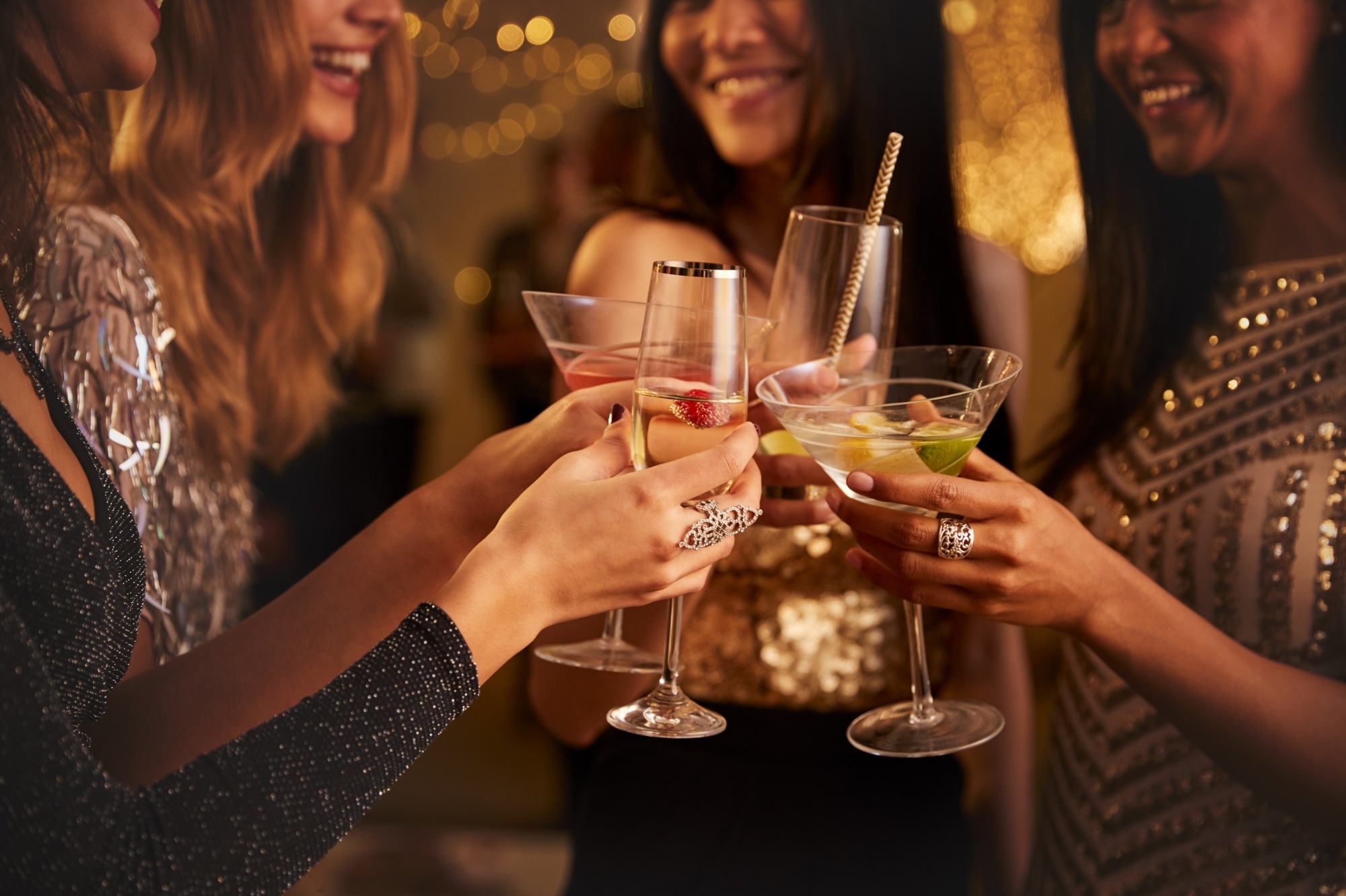 People clinking wine glasses at a party