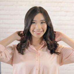 Asian woman touching her half curls blowout hairstyle for thin hair