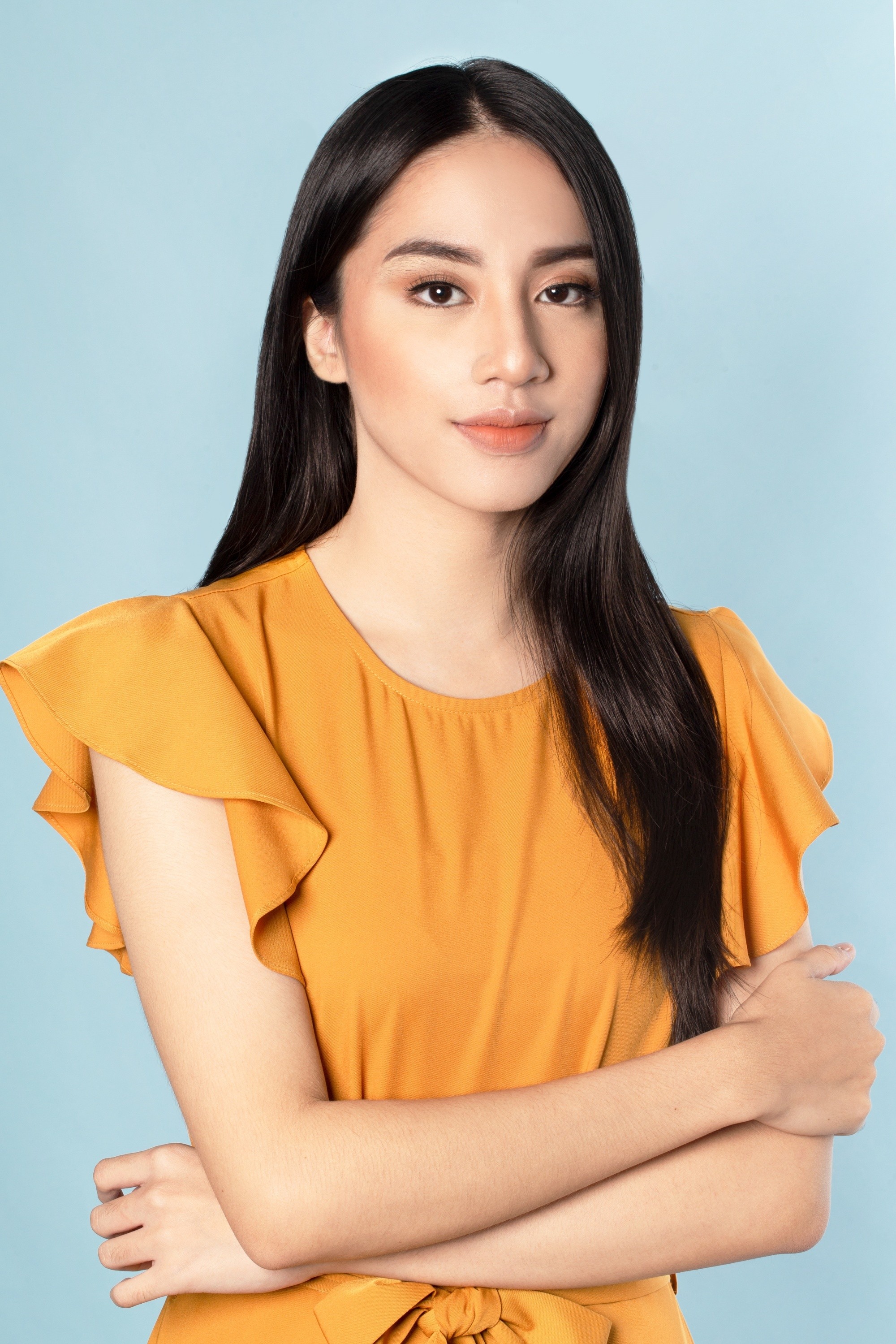 Hair Breakage Treatment: Asian woman with long black hair wearing a mustard-colored top