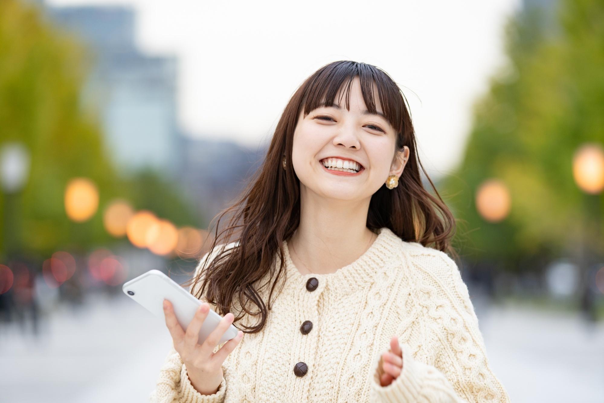 Asian woman with long tousled hair with bangs smiling