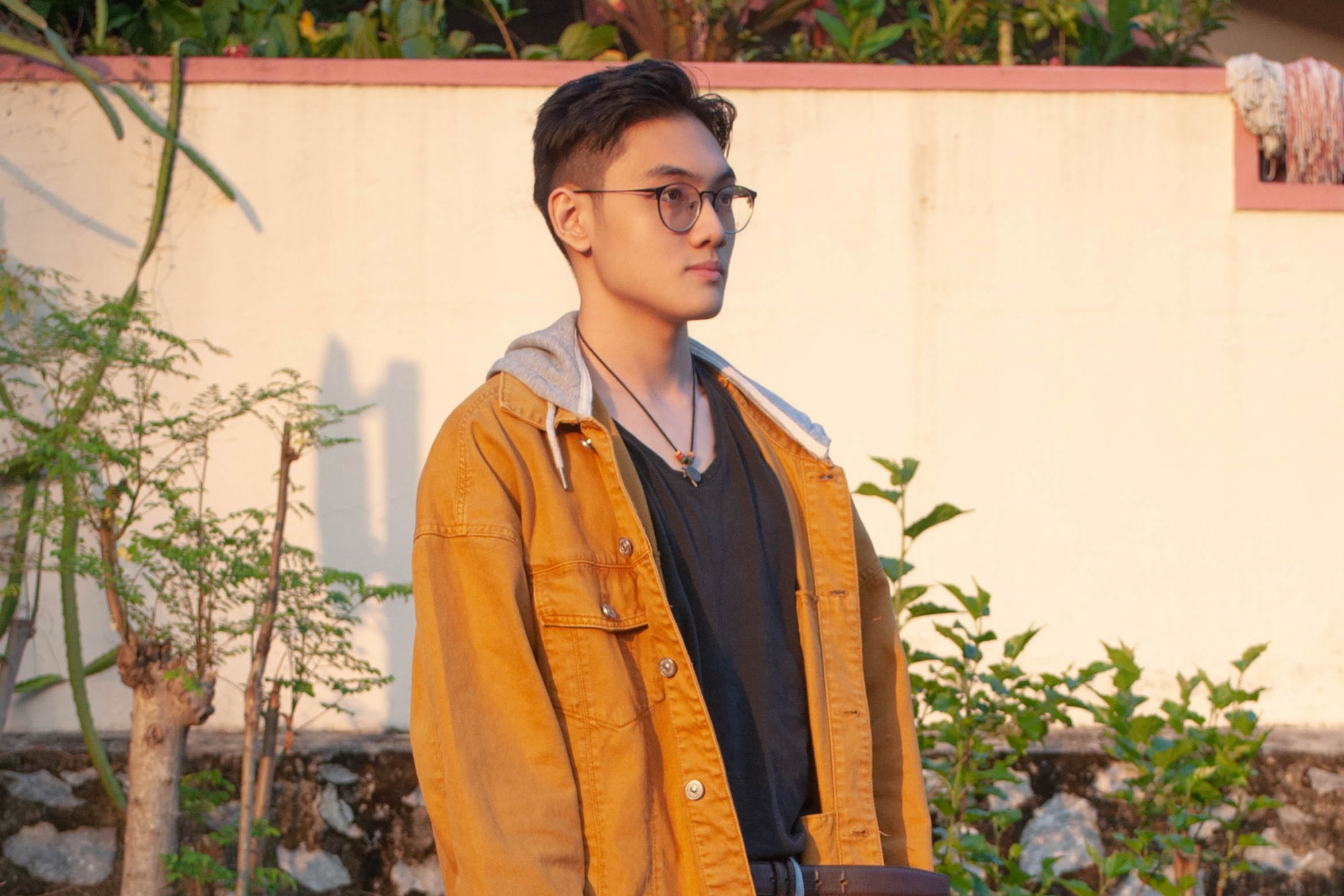 Asian with a trendy hairstyle and undercut wearing an orange jacket