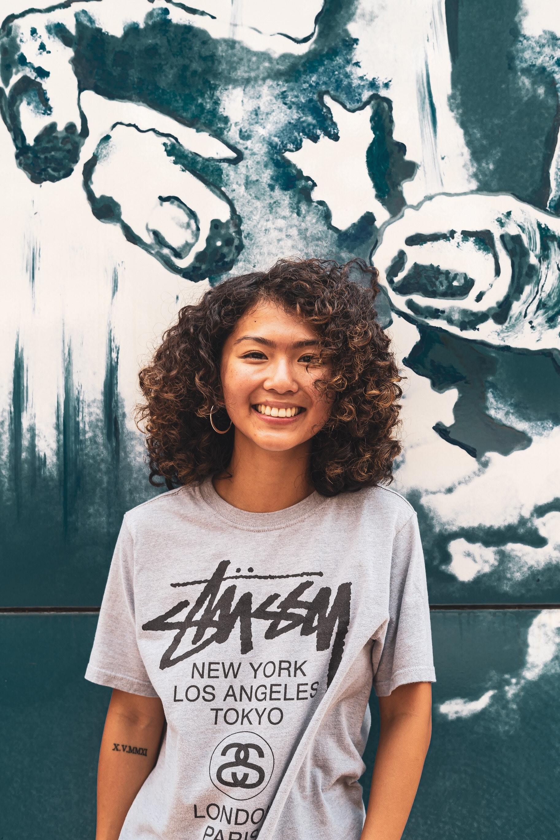 Asian woman with dark curly hair with highlghts