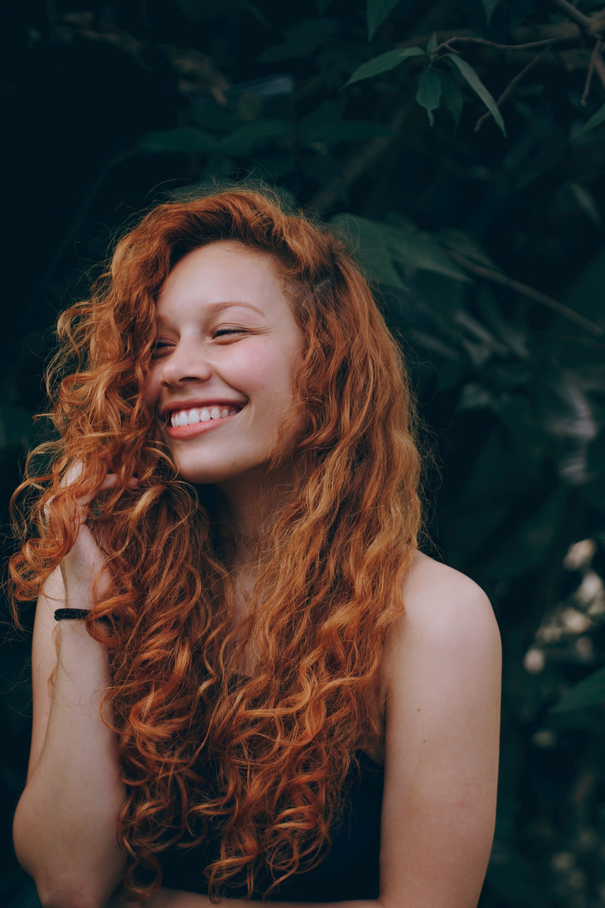 Woman with long coppery curly hair color