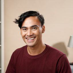 Men's hair: Asian man with short hair wearing a maroon shirt smiling