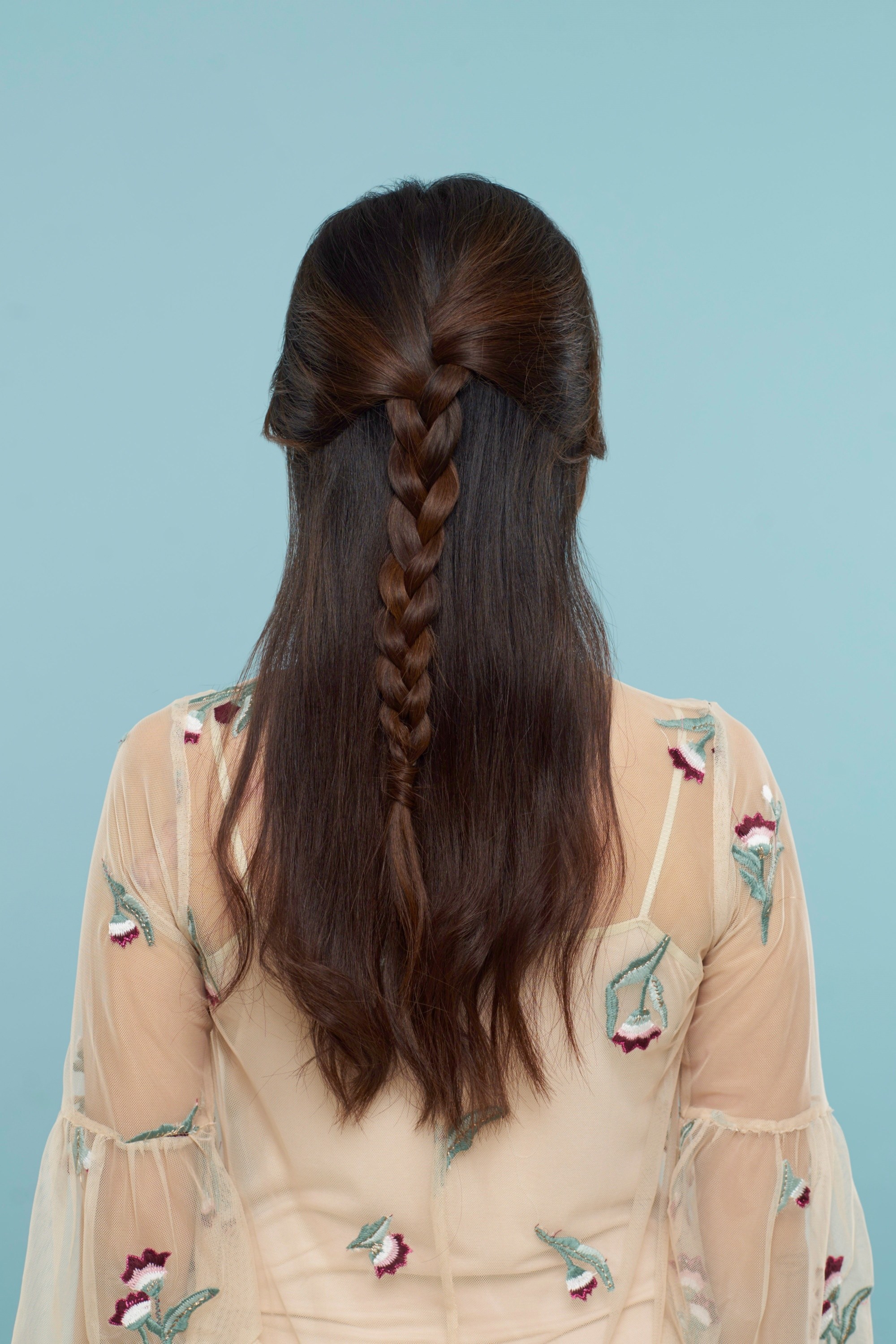 Back of an Asian woman with a half-up braided hairstyle