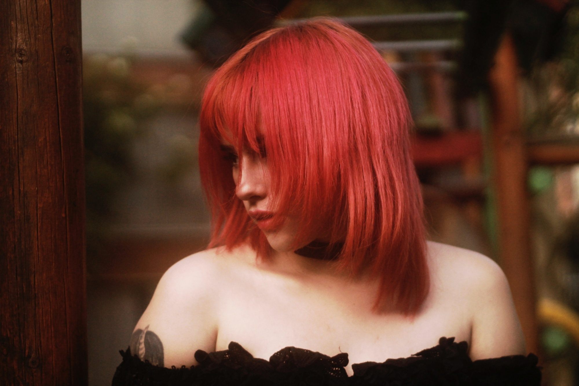 Woman with red layered hair and bangs looking at the side