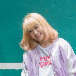 Asian woman with bleached blonde hair smiling