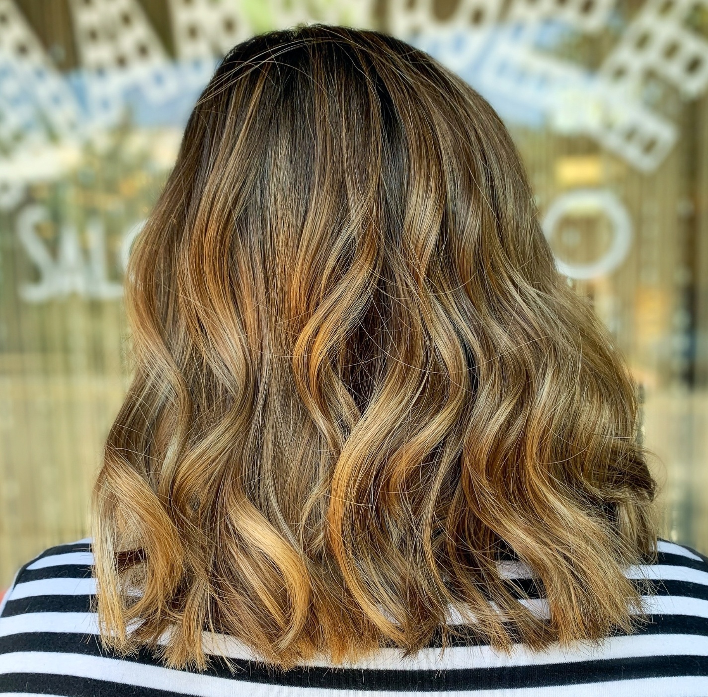 Woman facing back with light brown hair balayage highlights