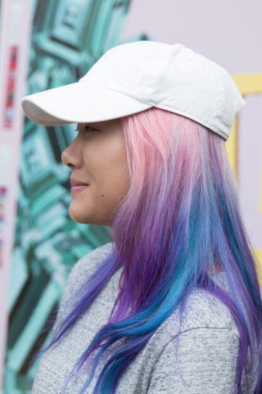 Woman with unicorn hair wearing a cap
