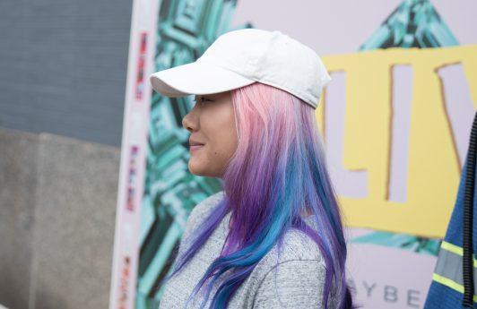 Woman with unicorn hair wearing a cap