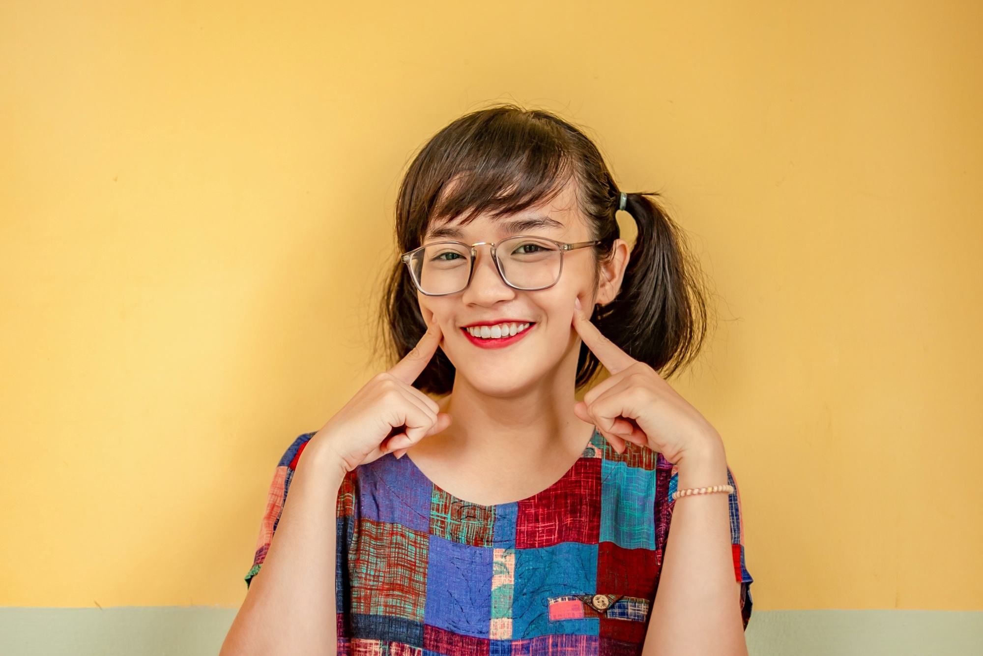 Asian woman with hair in pigtails wearing eyeglasses