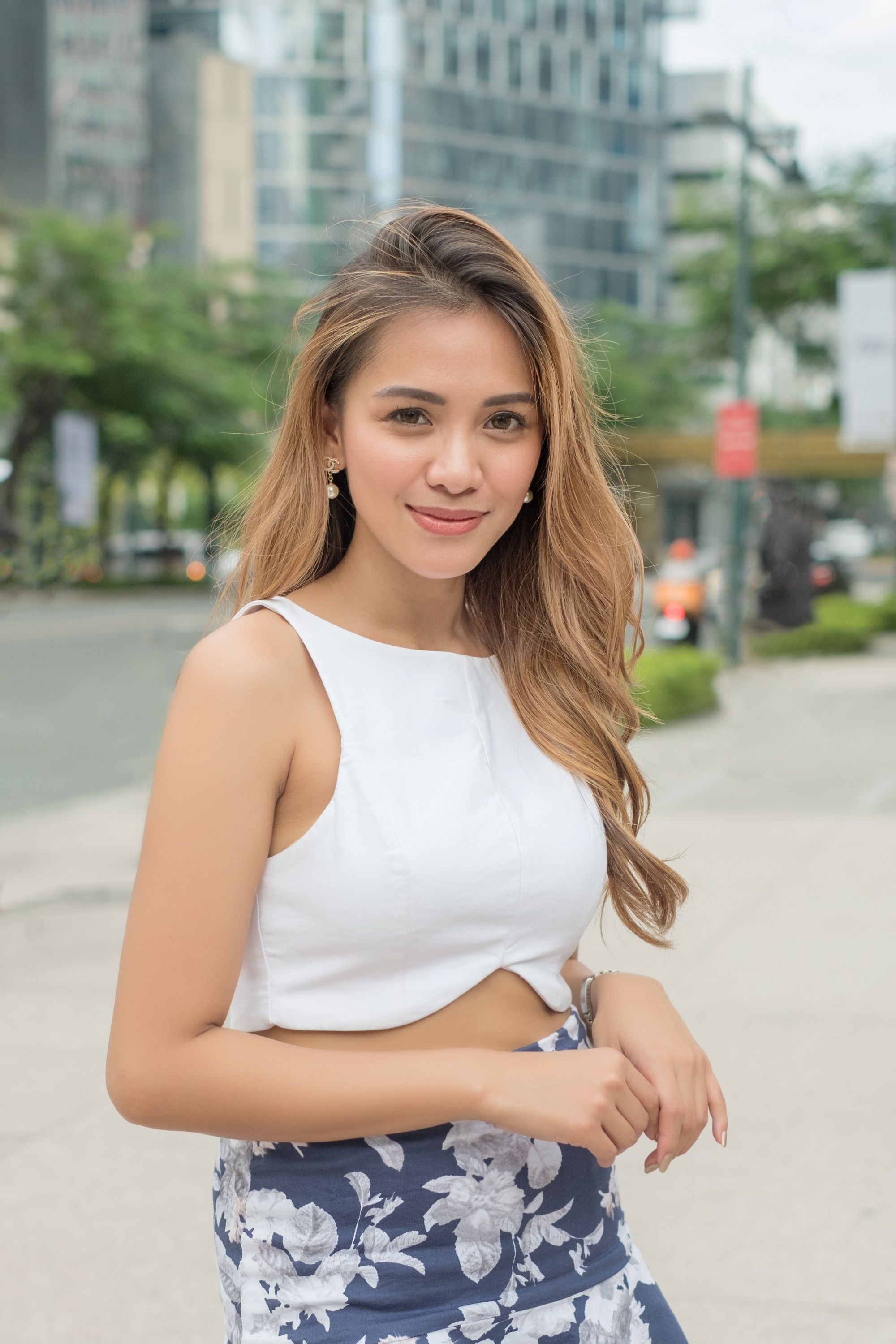 Hair Dye Ideas: Filipina with long golden brown hair wearing a white cropped top