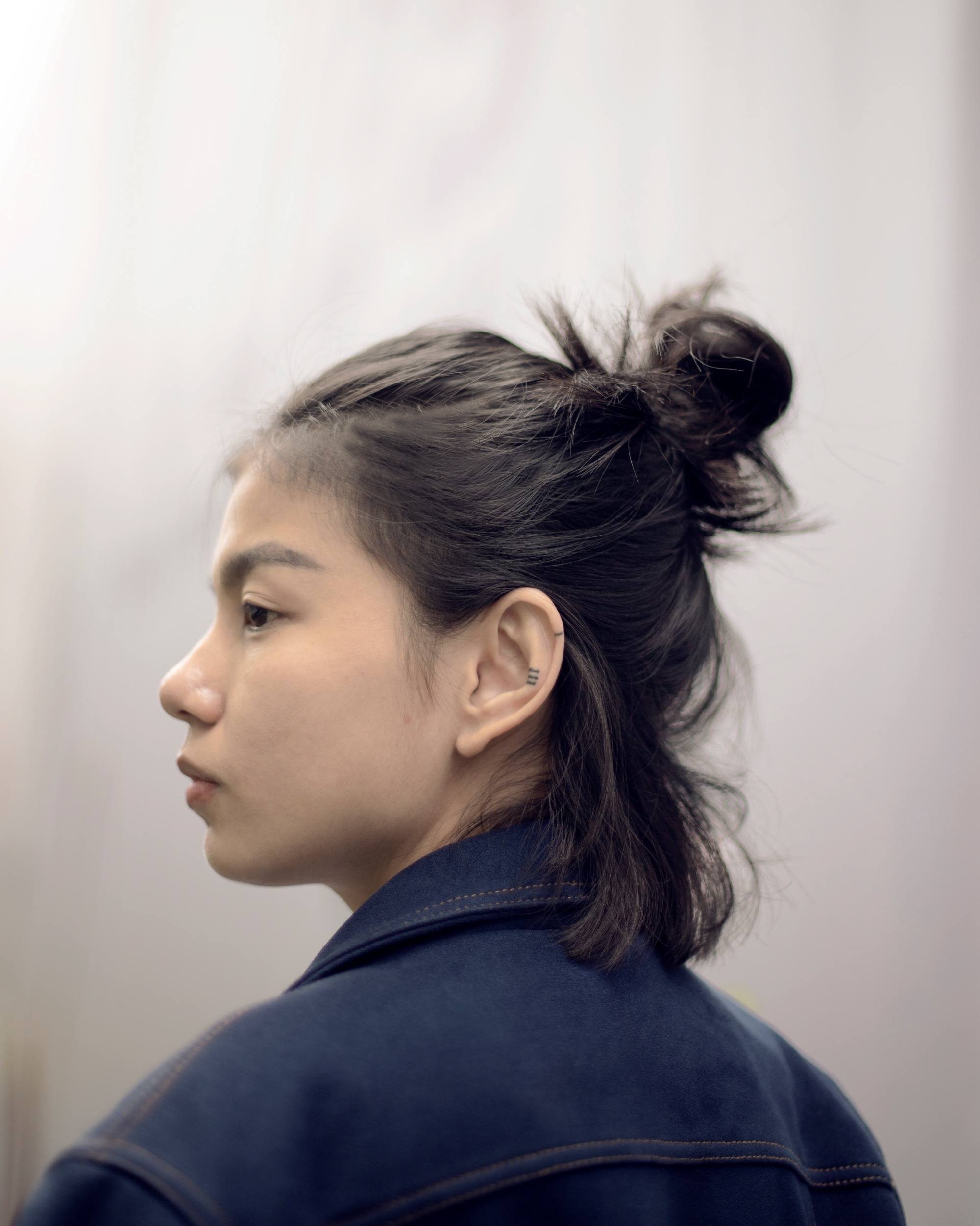 Asian woman with short hair in a messy half-up bun