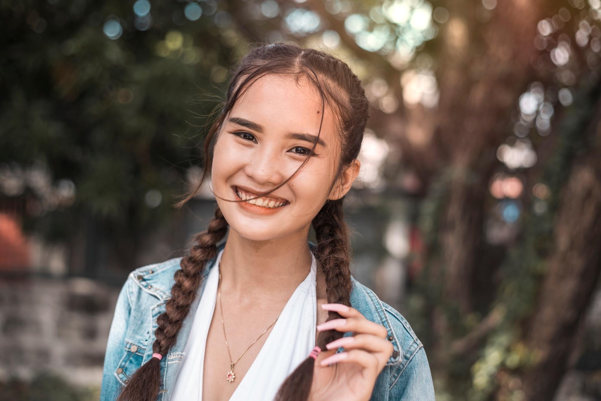 Asian woman with hair in pigtail braids