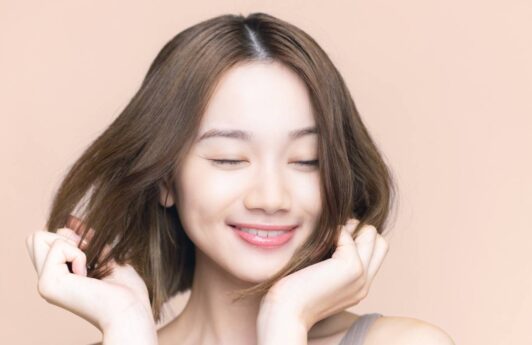 Asian woman touching her hair for a hair care routine concept