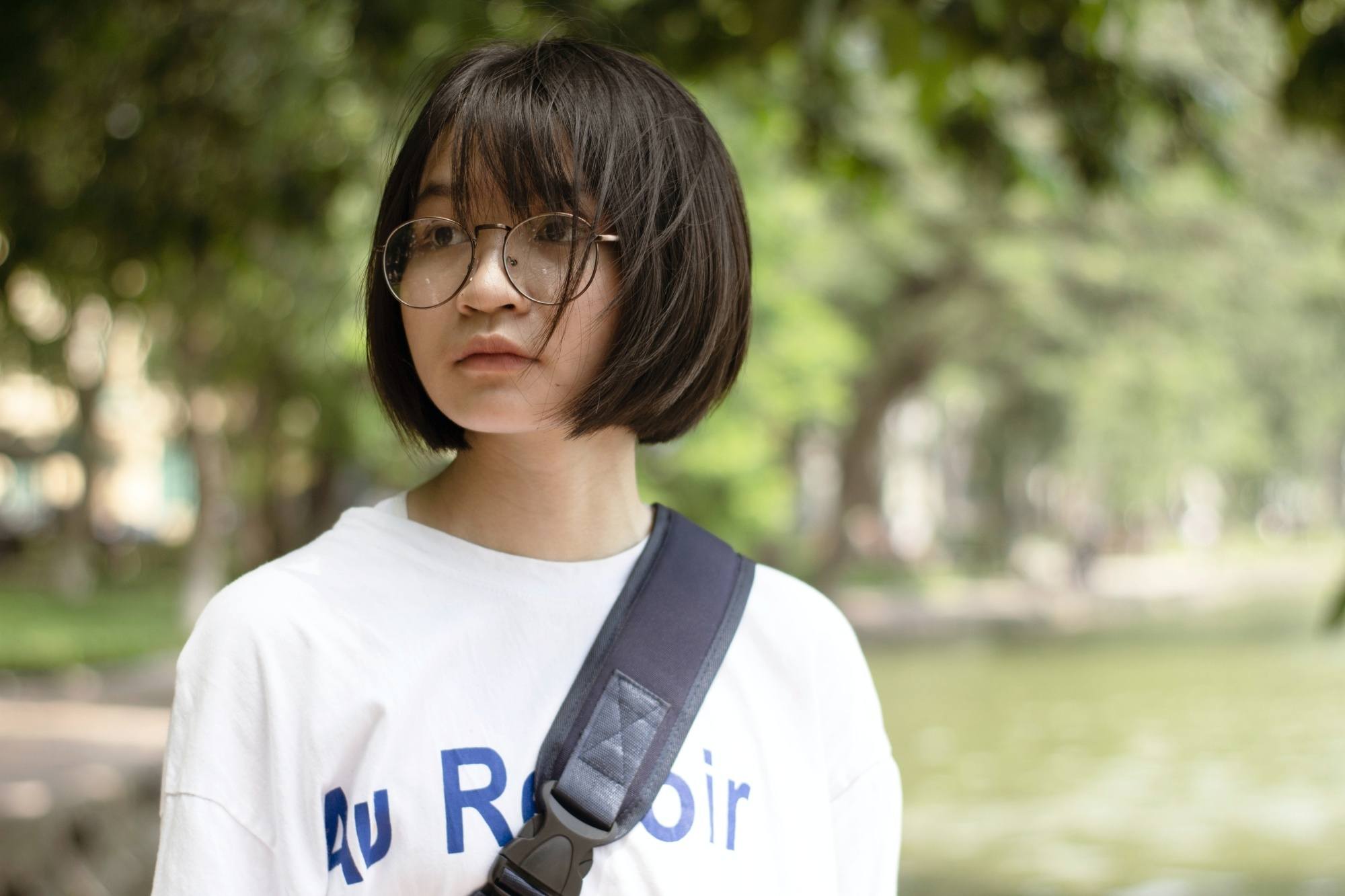 Femme asiatique avec un carré court avec une frange portant des lunettes