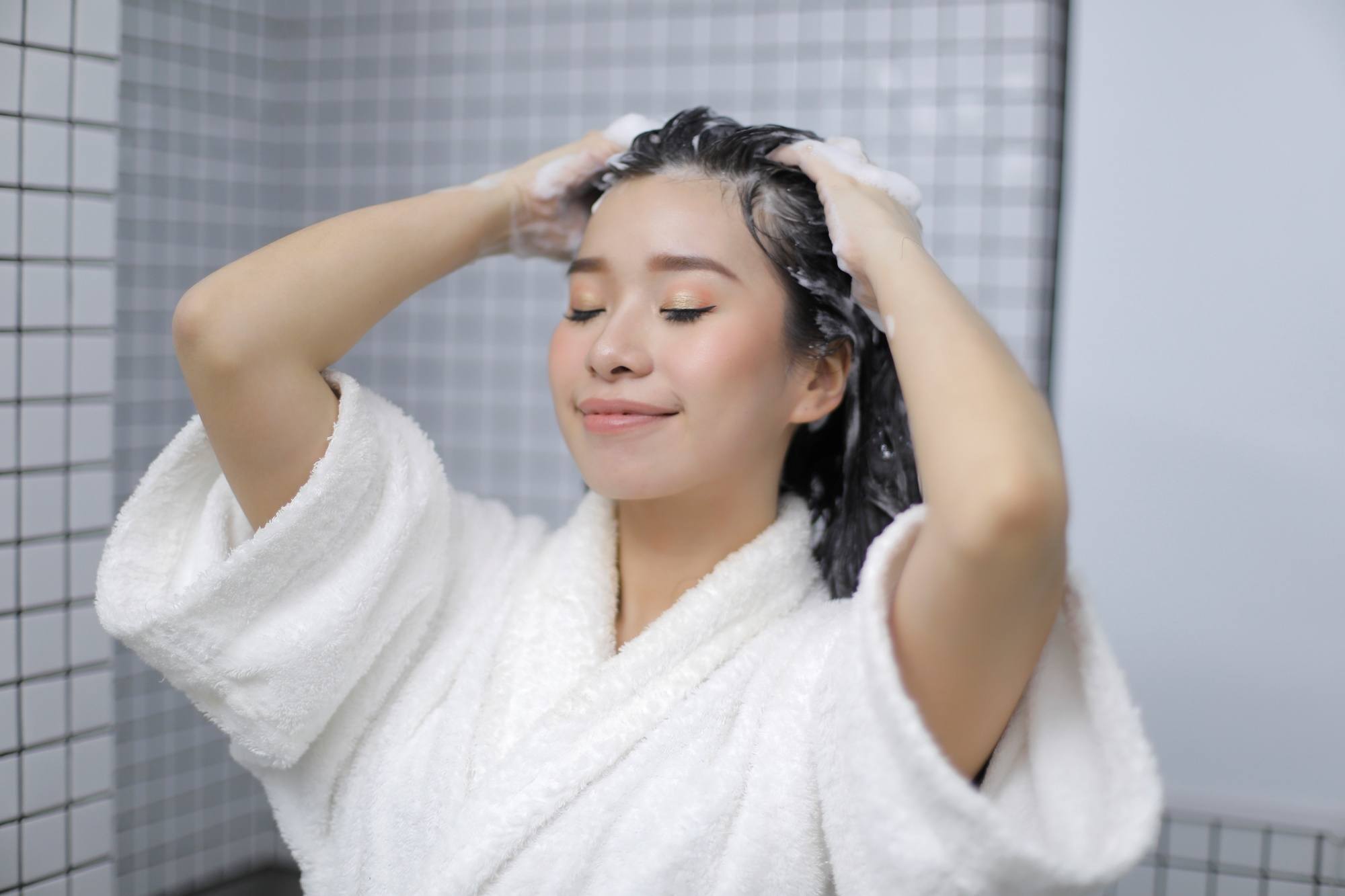 Asian woman shampooing her hair hair