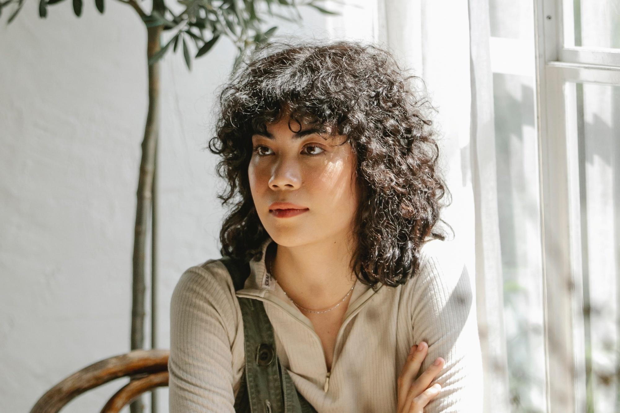Woman with a curly shag haircut with bangs
