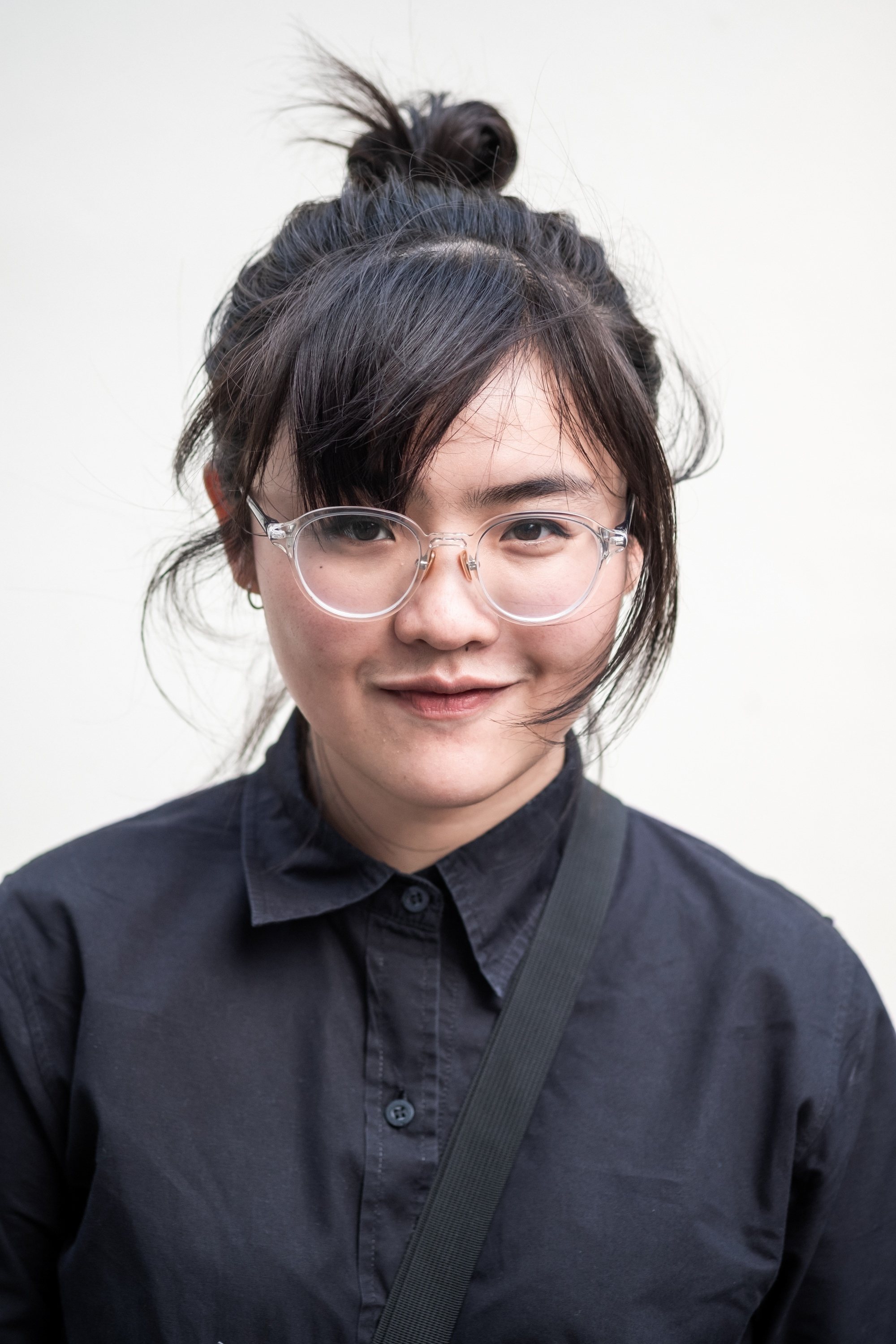 Asian woman with an androgynous bun hairstyle