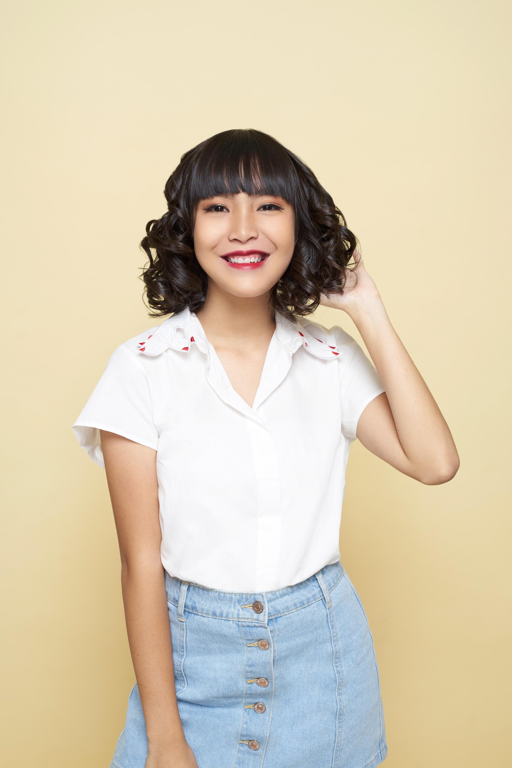 Asian woman touching her short hair curled using flat iron