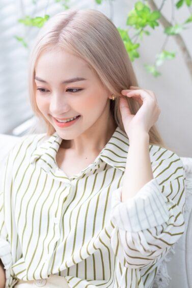 Brassy Hair No More: Asian woman with long blonde hair using a smartphone