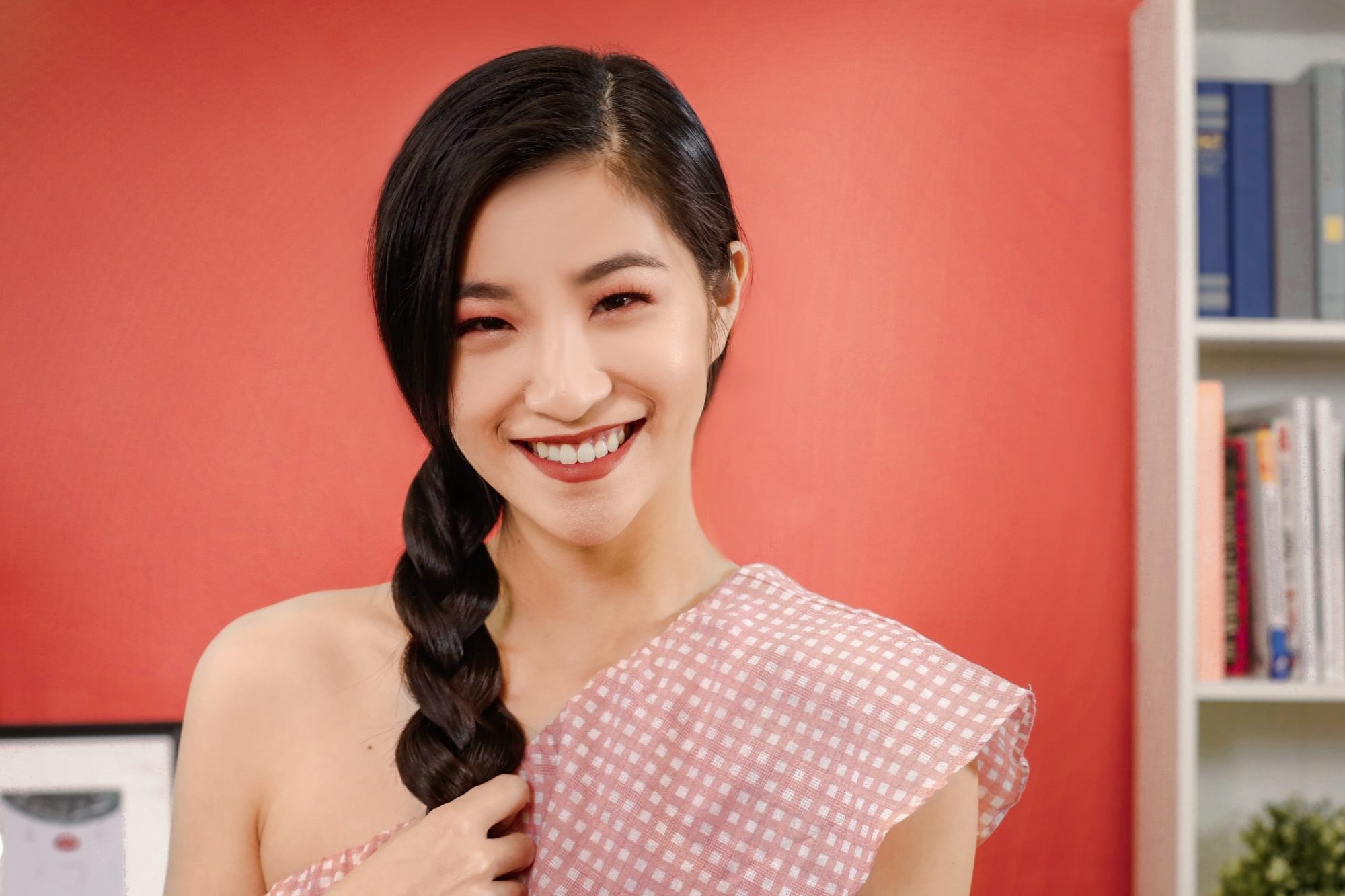 Asian woman with a side braid wearing a read top