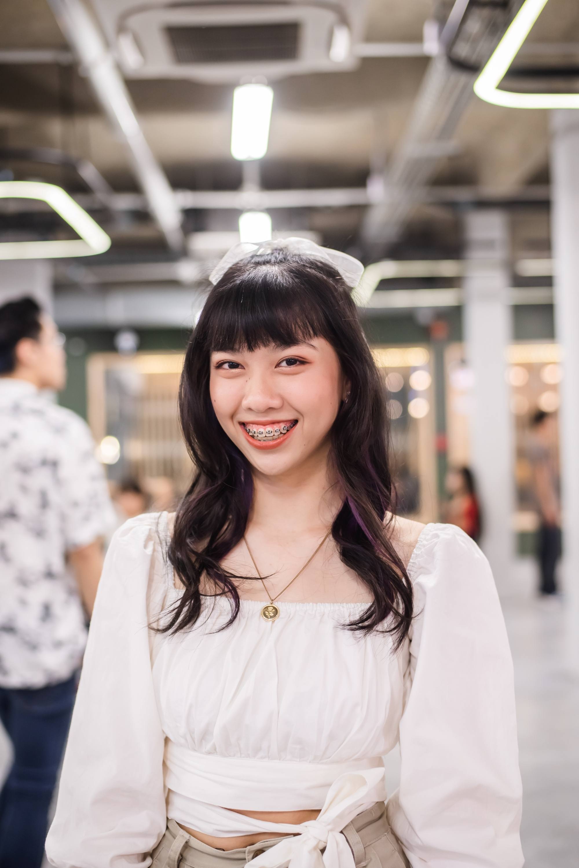 Asian woman with long wavy hair in a half updo
