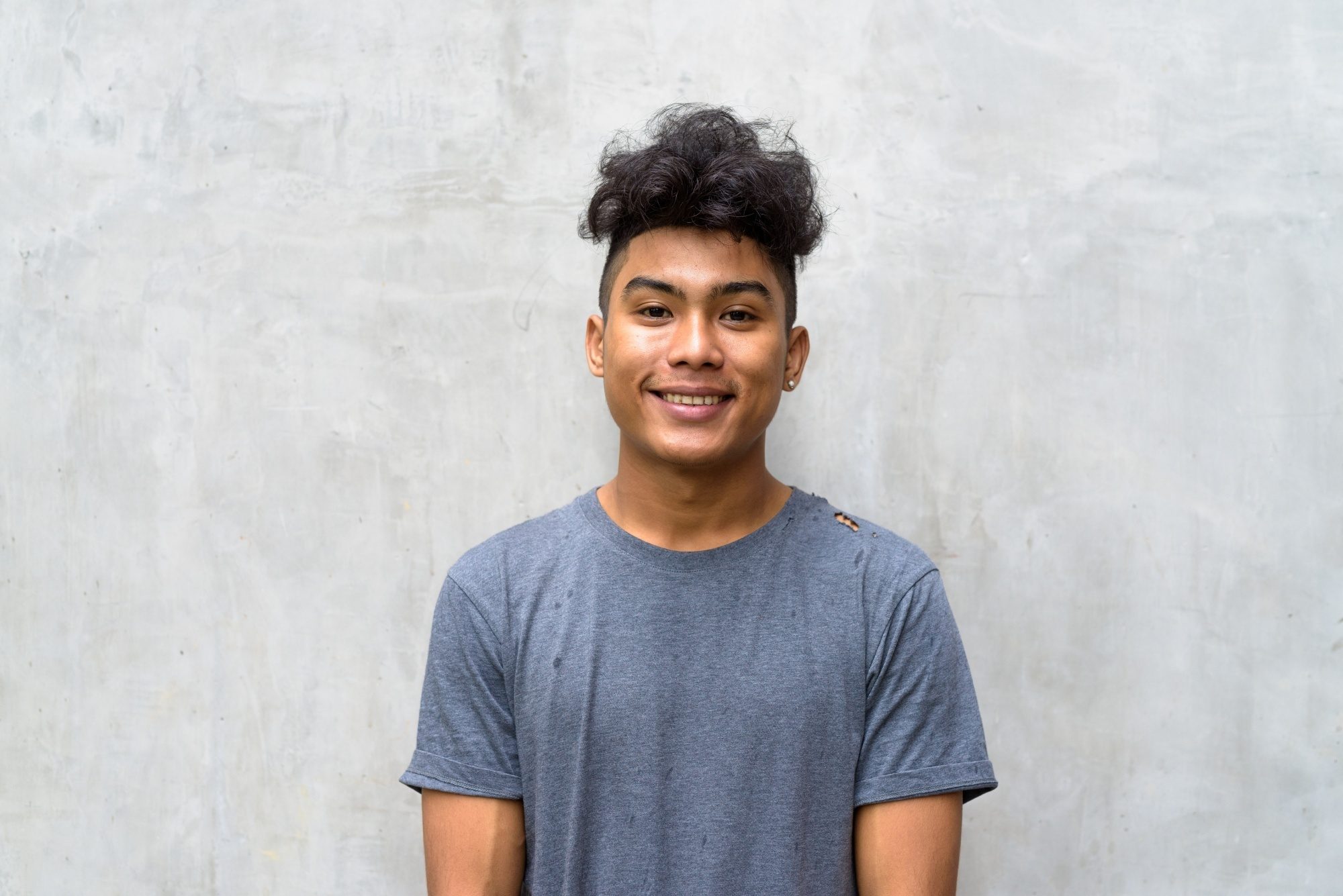 Asian man with curly hair and disconnected undercut