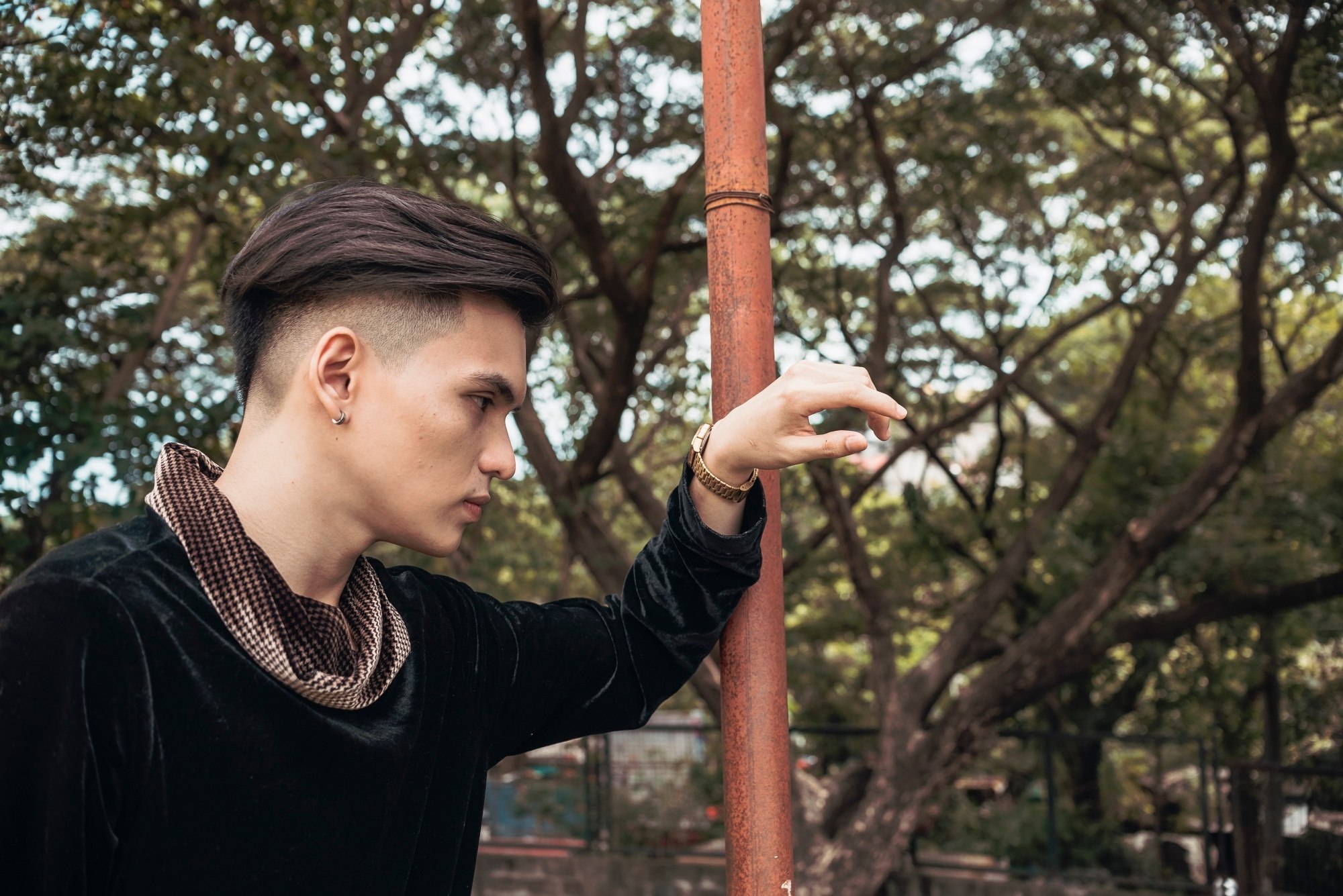 Side view of an Asian man with slicked-back hair and an undercut