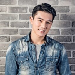 Asian man with a barber's cut with short back and sides and wearing a denim jacket