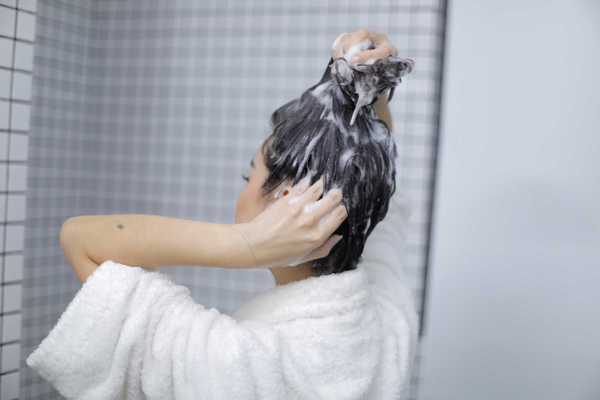 Asian woman washing and shampooing her hair