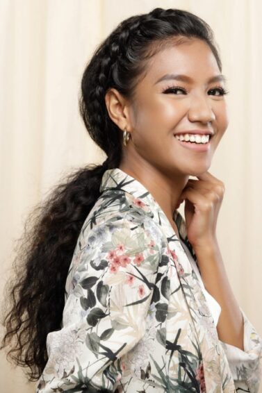 Asian woman with curly hair in a ponytail hairstyle