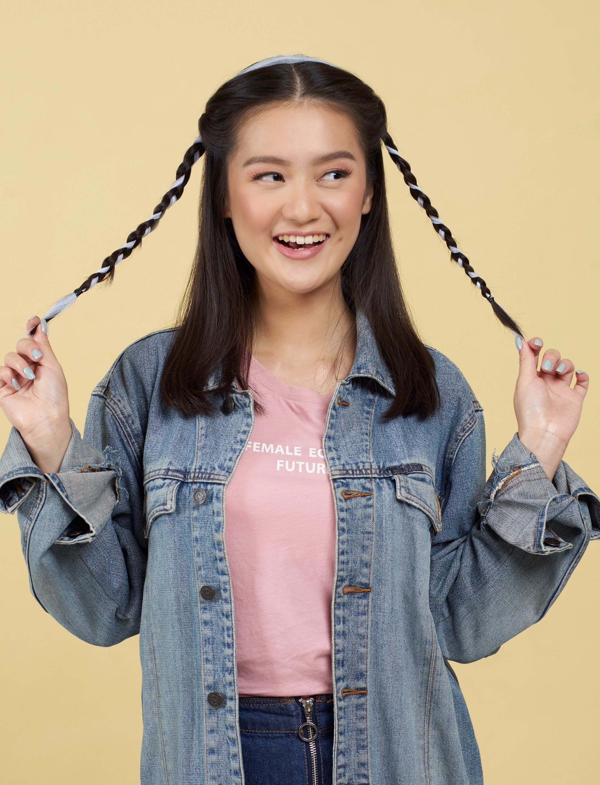 Asian woman with two side brands hairstyle with ribbon wearing a denim jacket.