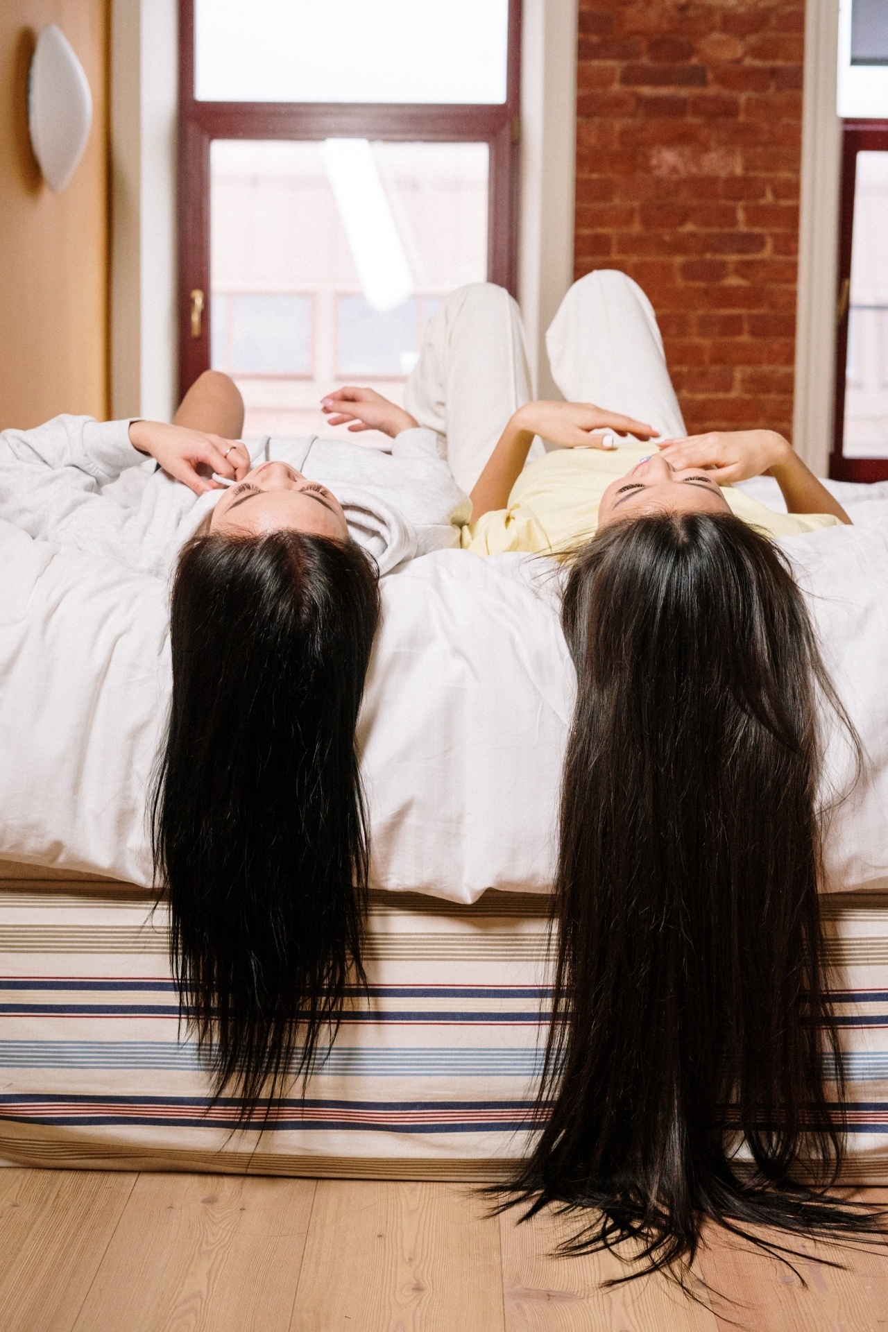Women with long hair in white shirt lying on bed