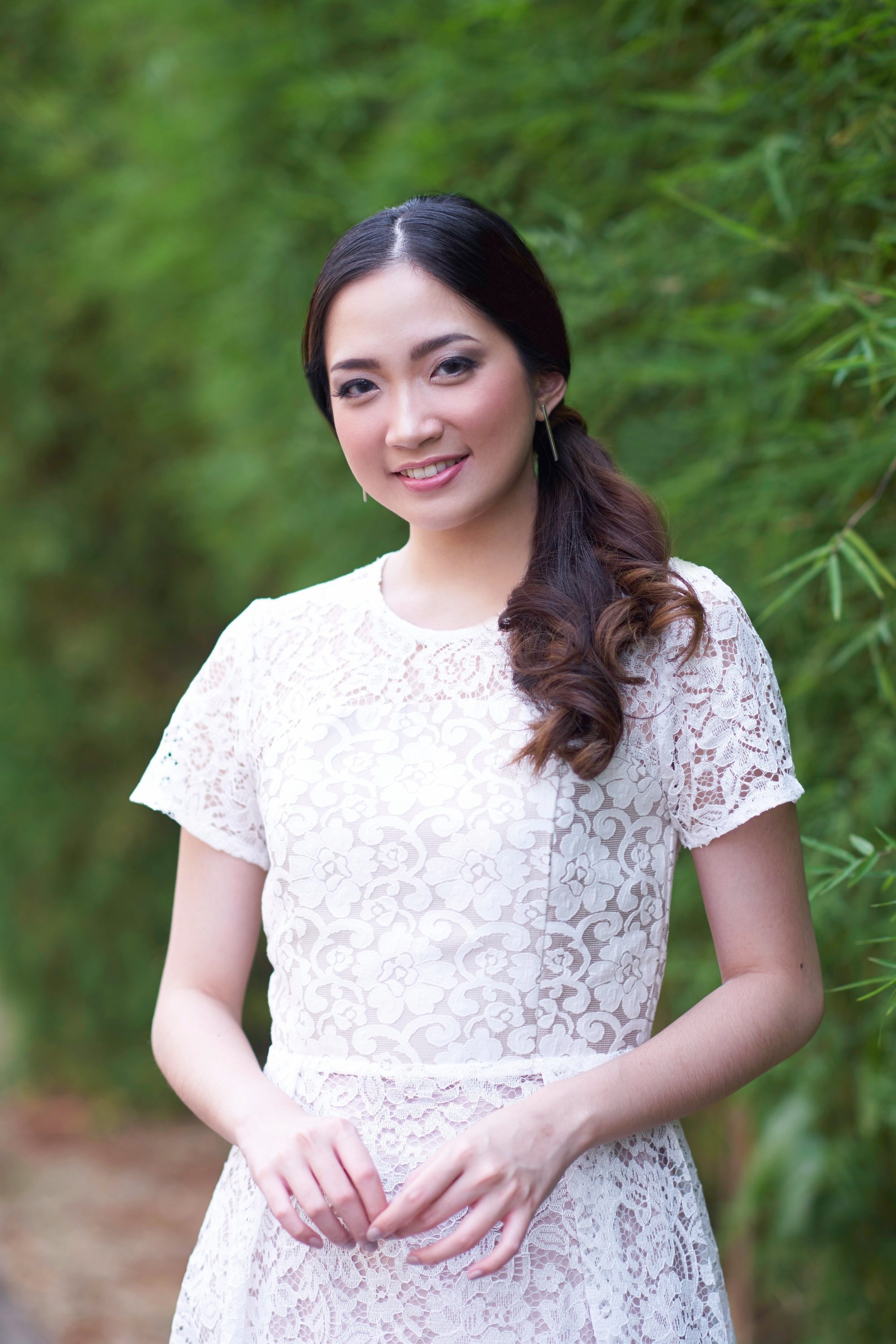 Asian woman with a curly side ponytail hairstyle for prom