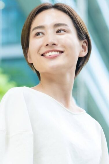 Asian woman with short layered hair wearing a white blouse