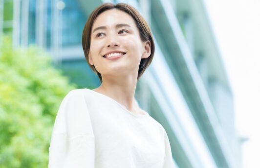 Asian woman with short layered hair wearing a white blouse