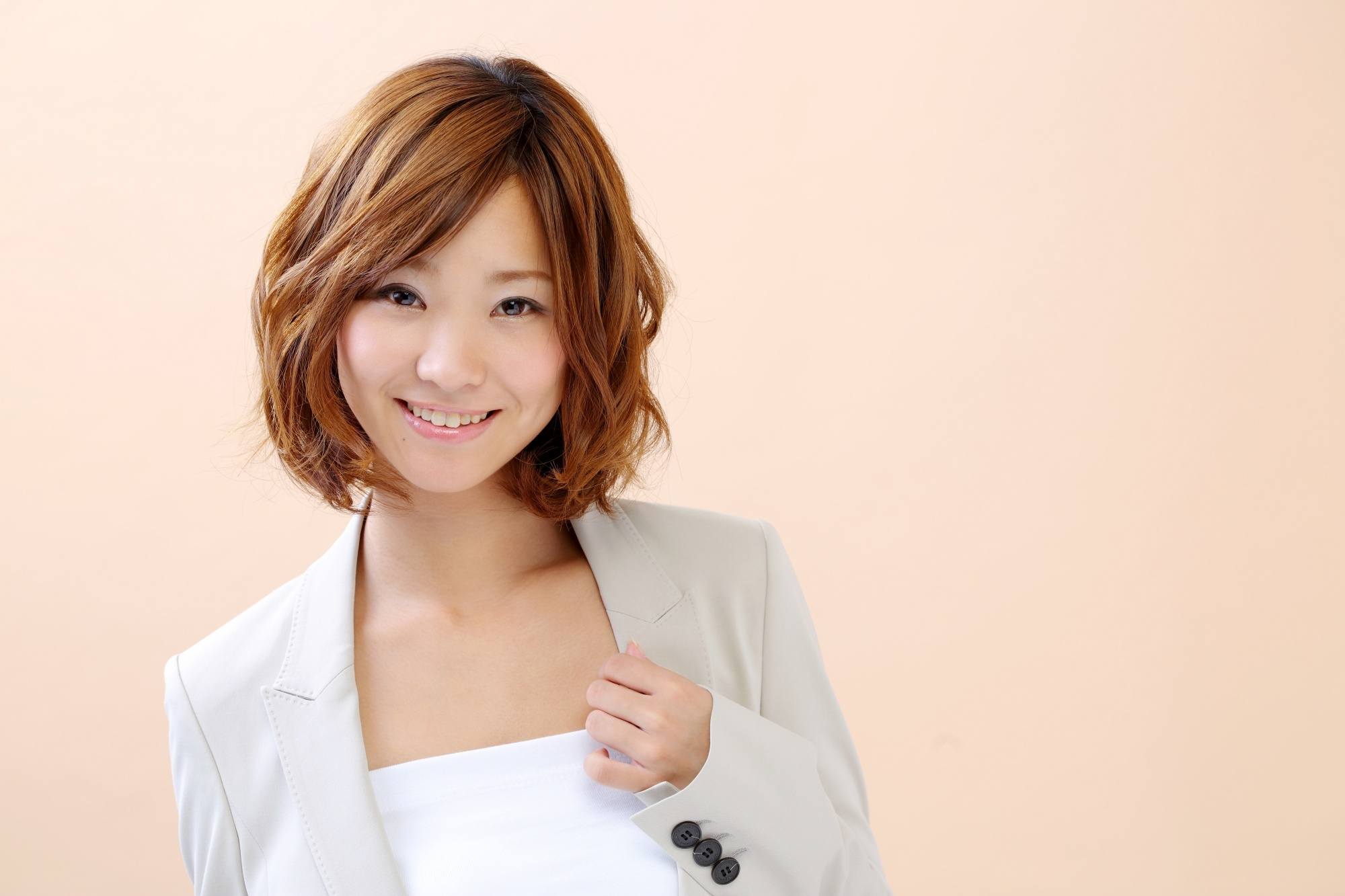 Asian woman with short caramel hair wearing a blazer