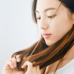 Asian woman touching her hair, worried about her dream about losing hair