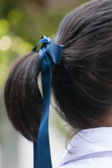 Back of an Asian woman with a ponytail tied by a ribbon hair tie